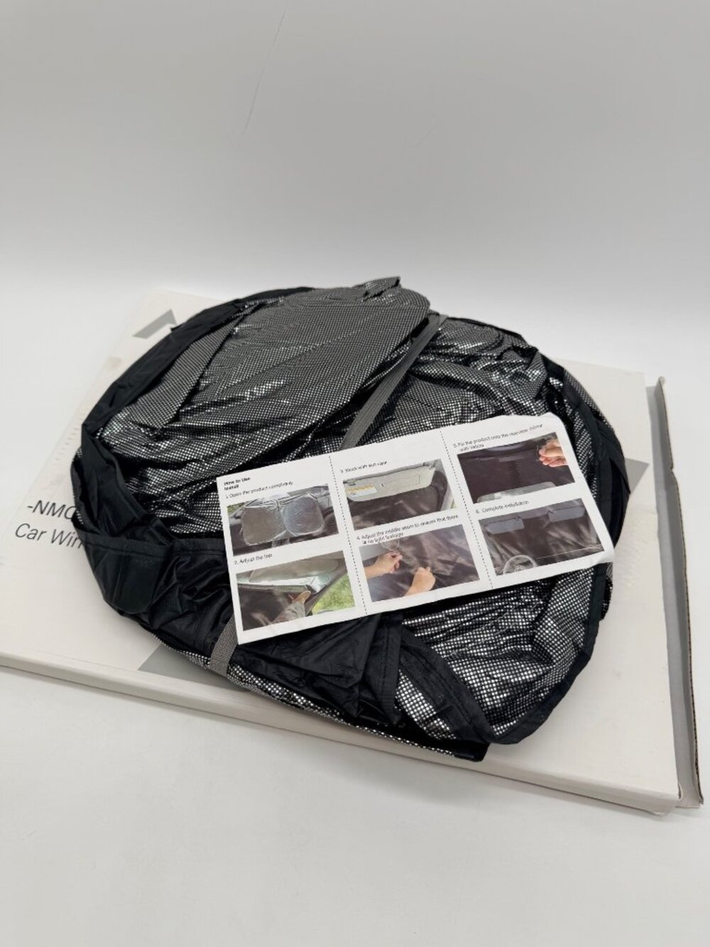 Nmoiss car windshield shade model QD001. Black foldable sunshade comes with stor